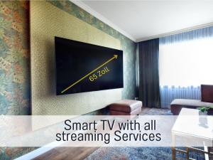 ein Wohnzimmer mit einem Fernseher an der Wand in der Unterkunft SUPERIOR LIVING - luxury and comfort in Bad Oeynhausen