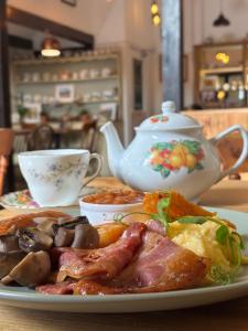 a plate of food on a table with a teapot at Thatched Cottage Hotel in Brockenhurst