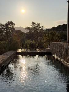 Una piscina de agua con dos sillas. en Villa Sabbia, en Lecci