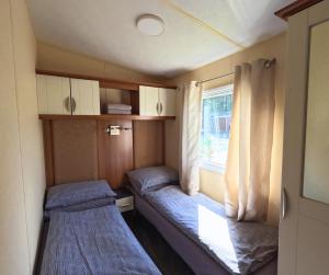 a small room with two beds and a window at Woodside, Meadows Retreat, Cockermouth in Plumbland +3 photos