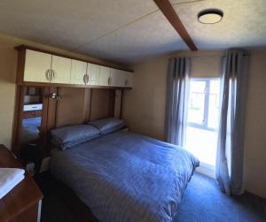 a small bedroom with a bed and a window at Woodside, Meadows Retreat, Cockermouth in Plumbland