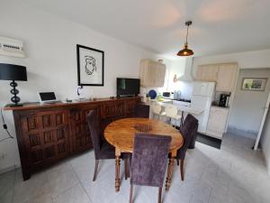 eine Küche und ein Esszimmer mit einem Holztisch und Stühlen in der Unterkunft Pause zen dans le Perche Nature & calme  + 27 Fotos