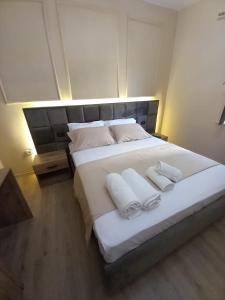a bedroom with a large white bed with two pillows at Eriks Rooms in Tirana