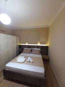 a bedroom with a bed with two towels on it at Eriks Rooms in Tirana