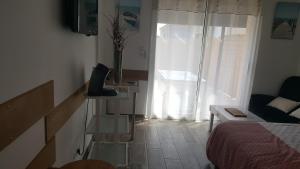 a room with a bed and a vase of flowers on a table at Pornic Studio in Pornic
