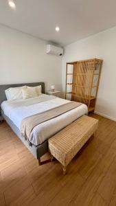 a bedroom with a large bed and a wooden floor at Casa do Mar in Ribeira Grande