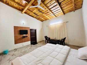 a bedroom with a large bed and a table at Lotus Lake View Inn in Bhīm Tāl