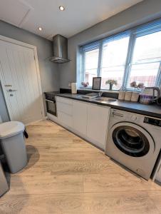 a kitchen with a washing machine and a sink at LuxeView - Stylish & Comfortable 1 Bedroom House in Chafford Hundred in North Stifford +13 photos
