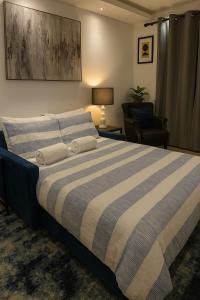 ein Schlafzimmer mit einem großen Bett und einem Stuhl in der Unterkunft LuxeView - Stylish & Comfortable 1 Bedroom House in Chafford Hundred in North Stifford