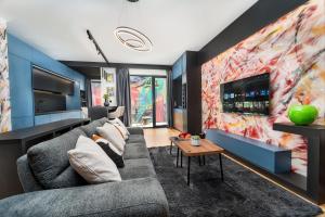 a living room with a couch and a tv at Central Paul Deluxe Apartment - by Open House in Timişoara