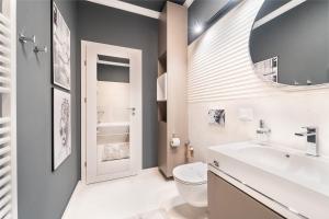 a bathroom with a sink and a toilet and a mirror at Central Paul Deluxe Apartment - by Open House in Timişoara +56 photos