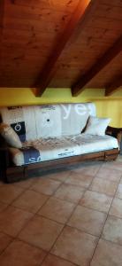 a bed in a room with a wooden ceiling at Casa Maria in Pettenasco