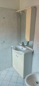 a white bathroom with a sink and a mirror at Casa Maria in Pettenasco +24 photos