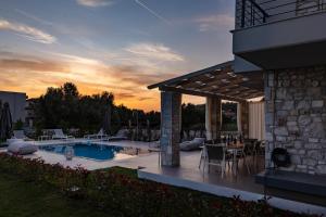 a patio with a table and chairs next to a pool at Olive Residence in Skala Fourkas