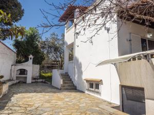 a white house with a stone walkway at St Nickolas Guest House in Artemida