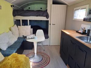 a small room with a bed and a table and a sink at De Zonnewagen in Sint Jacobiparochie