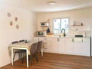 a kitchen with a table and some chairs and a counter at בקתה 512- אירוח בדרום הגולן in Giv'at Yo'av