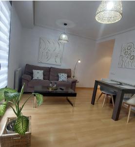 una sala de estar con un sofá y una mesa en Apartamento Vive Teruel, en Teruel