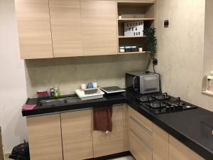 a kitchen with a stove and a microwave at BKC Nest 1BHK Studio Apartment in Mumbai +14 photos
