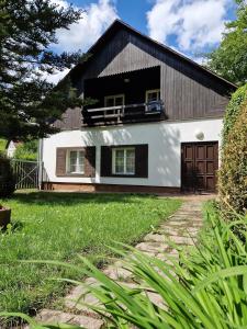 una grande casa bianca con tetto nero di Chalupa Hnízdo Jetřichovice a Jetřichovice