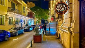 un grupo de autos estacionados en una calle por la noche en Hostel Baku Night, en Baku 55 fotos más