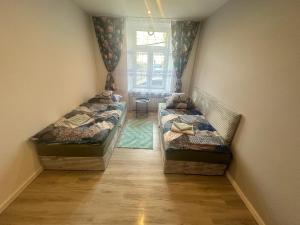 two beds in a small room with a window at Hostel w samym Centrum Radomia ! in Radom