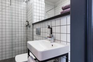 biała łazienka z umywalką i toaletą w obiekcie Stary Rynek Old Market Apartments w Poznaniu