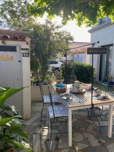 a wooden table and chairs on a patio at A l'ombre du platane in Marseille