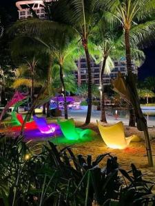 a beach at night with palm trees and a hammock at Althea's relaxing Condo Hotel in Sampong