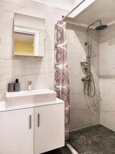 a white bathroom with a sink and a shower at Sokrates Apartments in Preveza