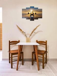 a dining room table with two chairs and a vase at Sokrates Apartments in Preveza