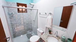 a bathroom with a toilet and a sink and a shower at Apartamento lençóis 103 in Lençóis +14 photos