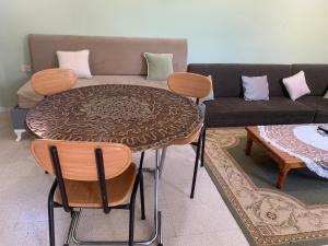 a table and chairs in a living room with a couch at Le Typique Djerbien in Houmt Souk