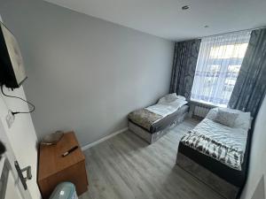 a small room with two beds and a window at Hostel w samym Centrum Radomia ! in Radom +17 photos