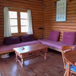 a living room with purple couches and a table at Gîte de montagne Las Trinquades in Boussenac +6 photos