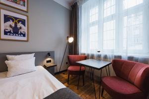 pokój hotelowy z łóżkiem, stołem i krzesłami w obiekcie Stary Rynek Old Market Apartments w Poznaniu