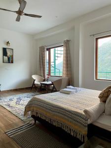 a bedroom with a bed and a couch and a window at Villa Aavaas 2 in Kukri Ser