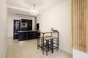 a kitchen with black cabinets and a table in it at La Terrasse du Bonheur in Le Mans