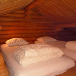 two beds in a room with wooden walls at Gîte de montagne Las Trinquades in Boussenac