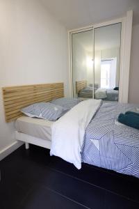 a bedroom with two beds and a large mirror at La Terrasse du Bonheur in Le Mans