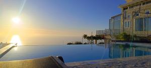 een zwembad in een gebouw met de ondergaande zon bij Villa Matula in Kalamitsi