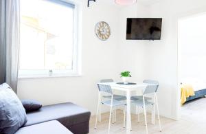 a white living room with a white table and chairs at Przy Plaży in Karwia