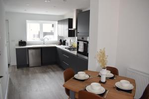 a kitchen and dining room with a wooden table at Tolson Court House in Fazeley