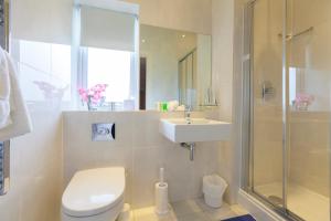 a bathroom with a toilet and a sink and a shower at Dudsbury Golf Club - Hotel And Spa in Ferndown