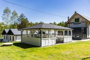 a large white gazebo in the yard of a house at Camping skansen Zdbice - domek letniskowy 1 in Zdbice +19 photos