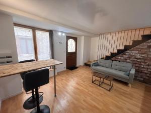 a living room with a couch and a table at Cinema room - Proche Auxerre in Vincelles