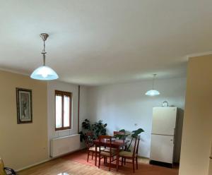 a living room with a table and a white refrigerator at Žabljak Apartman in Žabljak