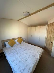 a bedroom with a large white bed with yellow pillows at Biggerstaffs retreat in Lossiemouth +48 photos