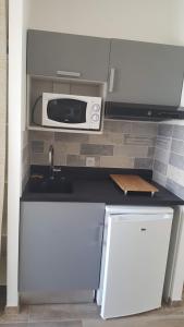 a kitchen with a sink and a microwave at Pornic Studio in Pornic