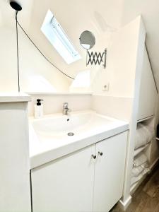 ein Badezimmer mit Waschbecken und Spiegel in der Unterkunft LE LAVADIÈRE - Joli duplex avec terrasse in Sèvres